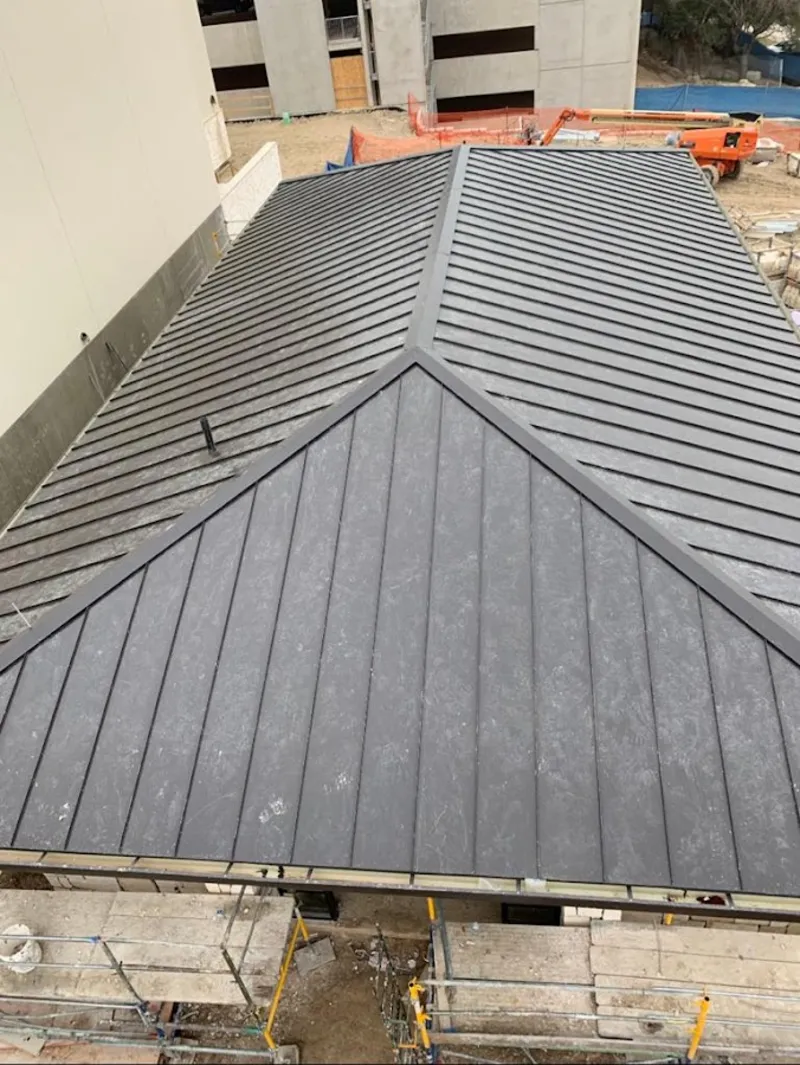 Commercial metal roof construction with crane equipment in Mesa
